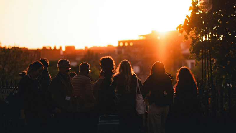 A group of young people looking at a golden sunset